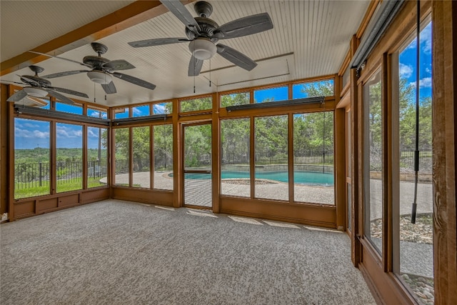 unfurnished sunroom featuring a healthy amount of sunlight and ceiling fan