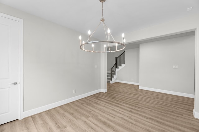 unfurnished dining area with a chandelier and light hardwood / wood-style floors