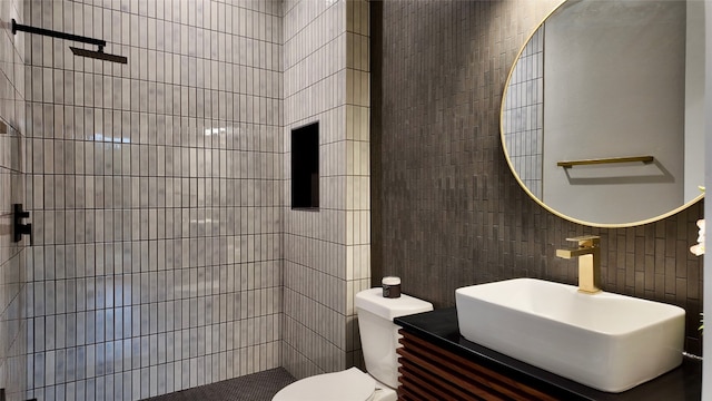 bathroom with tile walls, toilet, and vanity