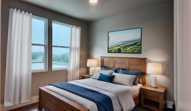 bedroom with ceiling fan and a water view