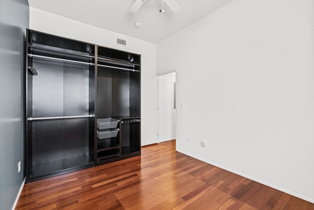 unfurnished bedroom featuring a closet, wood-type flooring, and ceiling fan