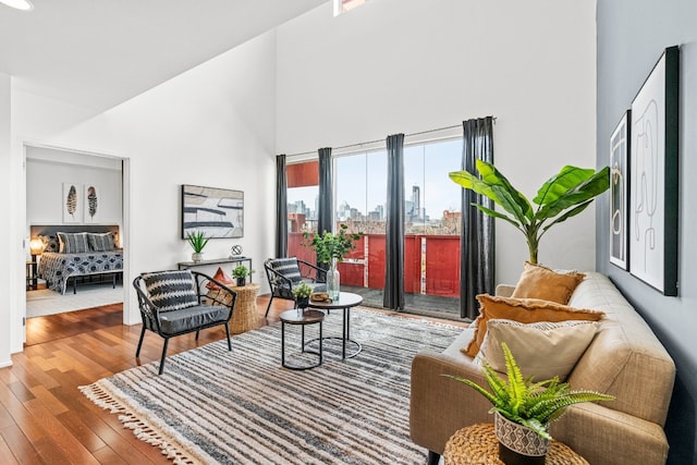 sitting room with a towering ceiling and hardwood / wood-style flooring