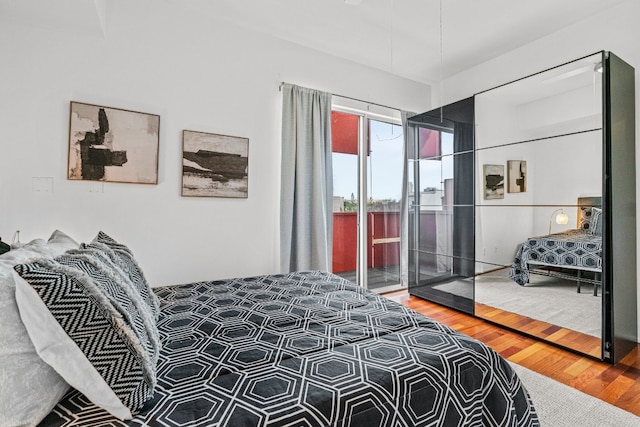 bedroom featuring wood-type flooring and access to exterior