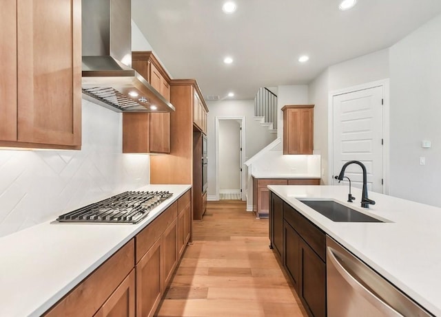 226 Flora Springs Cv, Liberty Hill, TX 78642 - kitchen featuring wall chimney exhaust hood, appliances with stainless steel finishes, a sink, light wood finished floors, and light countertops