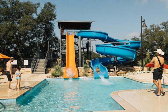 226 Flora Springs Cv, Liberty Hill, TX 78642 - community pool featuring a water slide, stairway, and a patio area