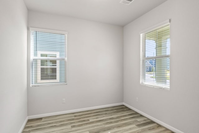 unfurnished room featuring light hardwood / wood-style floors and plenty of natural light