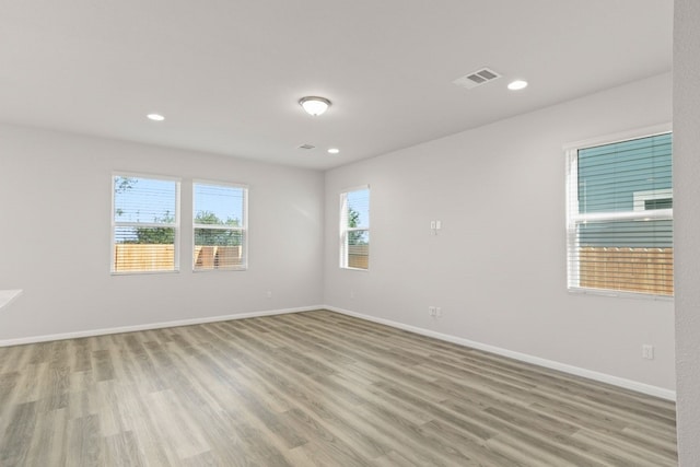 spare room with light wood-type flooring and a healthy amount of sunlight