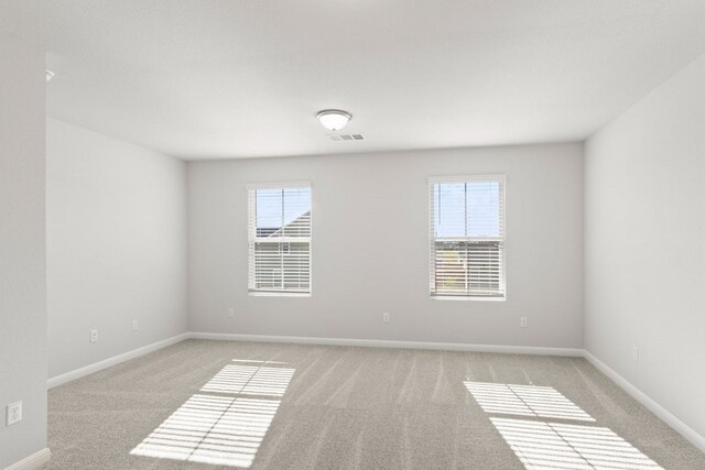 empty room featuring light carpet and a healthy amount of sunlight