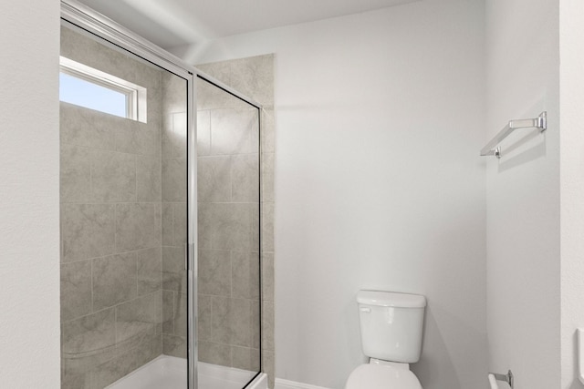 bathroom with toilet and a shower with shower door