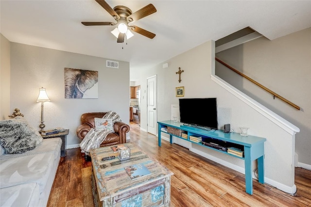 21461 Coyote Trl Unit 6, Lago Vista, TX 78645 - living room featuring a ceiling fan, wood finished floors, baseboards, and stairway