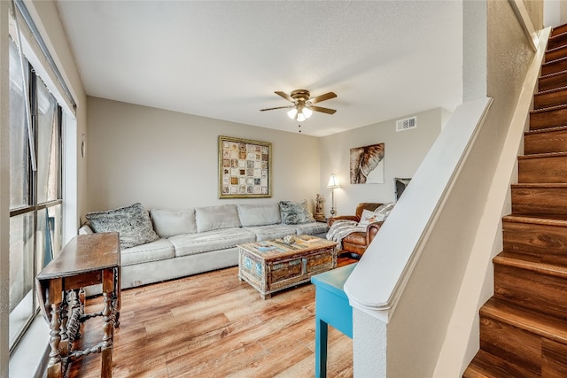 living room with wood-type flooring and ceiling fan