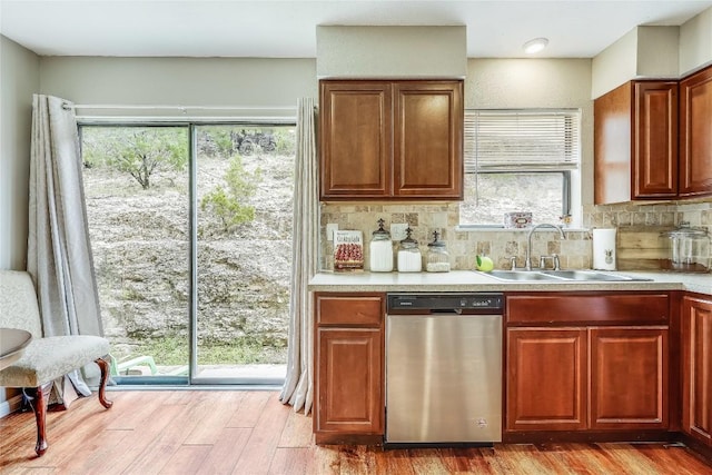 21461 Coyote Trl Unit 6, Lago Vista, TX 78645 - kitchen with stainless steel dishwasher, a sink, wood finished floors, light countertops, and backsplash