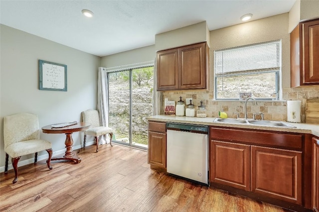 21461 Coyote Trl Unit 6, Lago Vista, TX 78645 - kitchen featuring dishwasher, a sink, light countertops, decorative backsplash, and light wood-style flooring