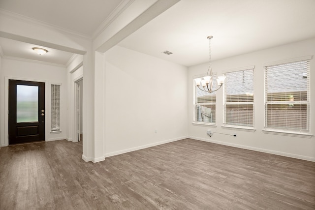 unfurnished dining area with dark hardwood / wood-style flooring, an inviting chandelier, and crown molding