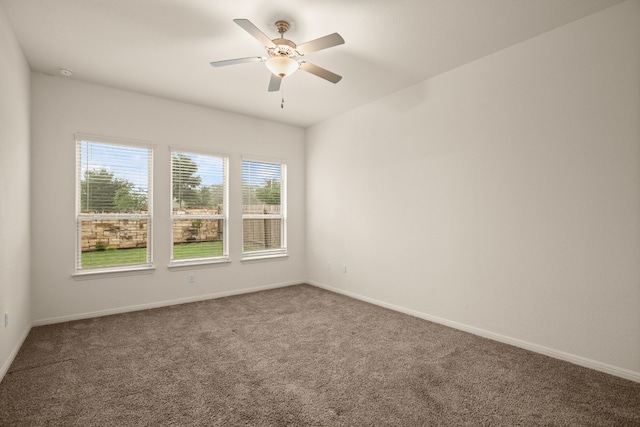 carpeted spare room featuring ceiling fan