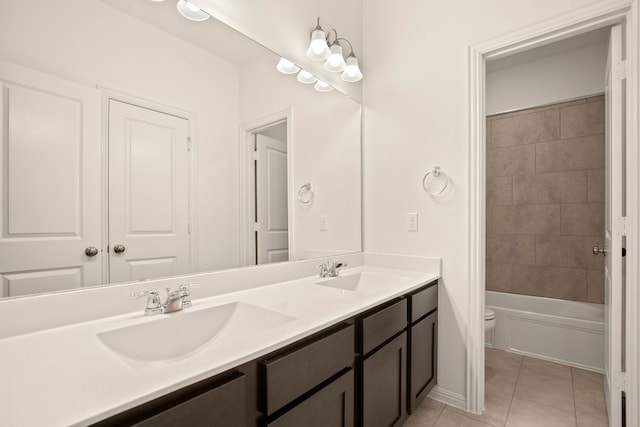 full bathroom featuring vanity, toilet, tile patterned flooring, and tiled shower / bath combo