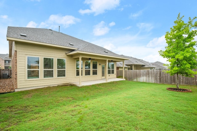 rear view of property featuring a lawn, central AC, ceiling fan, and a patio area