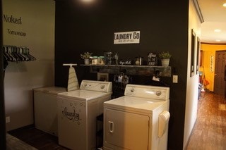 laundry area with wood-type flooring, washer hookup, and washing machine and clothes dryer