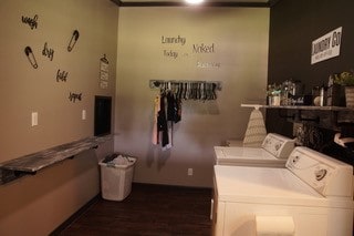 clothes washing area with washing machine and dryer and dark hardwood / wood-style flooring