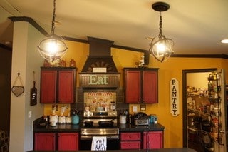 bar featuring hanging light fixtures, crown molding, premium range hood, and range