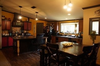 dining room with plenty of natural light, ornamental molding, vaulted ceiling, and hardwood / wood-style flooring