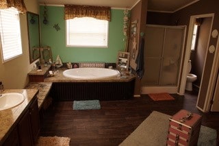 full bathroom featuring vanity, hardwood / wood-style flooring, plus walk in shower, and toilet