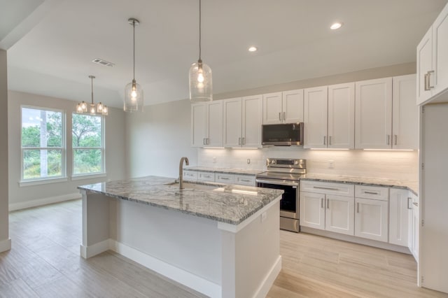 kitchen featuring white cabinetry, sink, hanging light fixtures, an island with sink, and appliances with stainless steel finishes