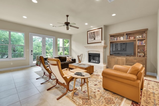 living room with french doors, built in features, ceiling fan, and light tile flooring