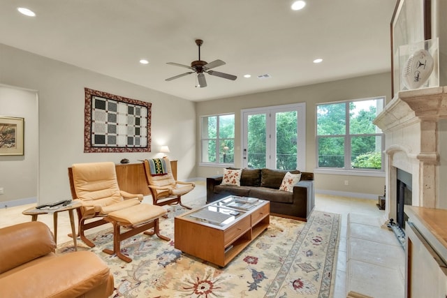 tiled living room featuring a high end fireplace and ceiling fan