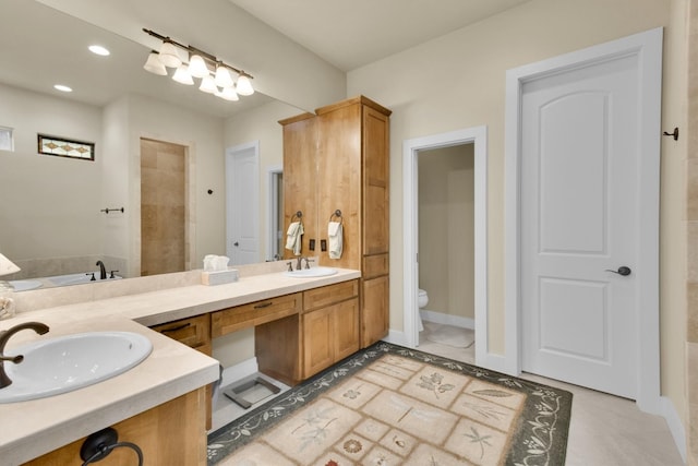 bathroom with tile flooring, toilet, and double sink vanity