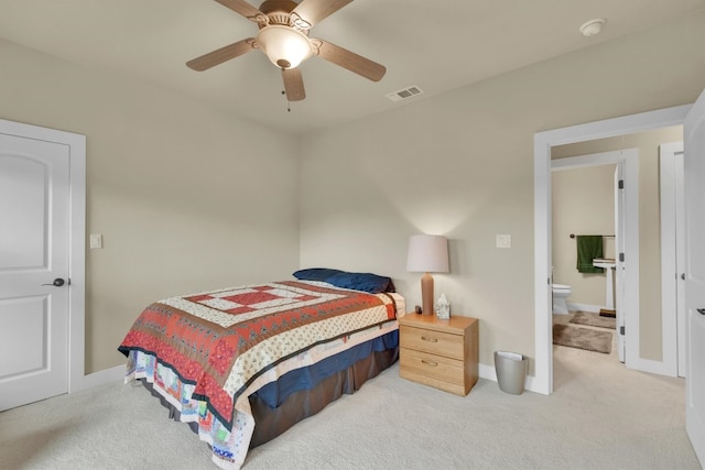 carpeted bedroom with ensuite bathroom and ceiling fan