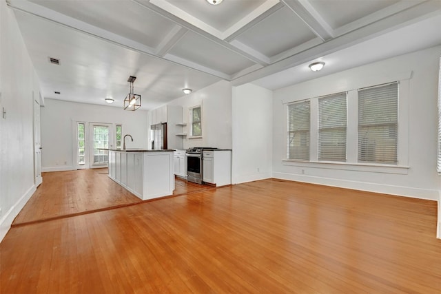 kitchen with white cabinets, light wood-type flooring, stainless steel appliances, an island with sink, and pendant lighting