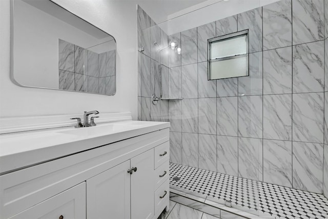 bathroom with tiled shower and vanity