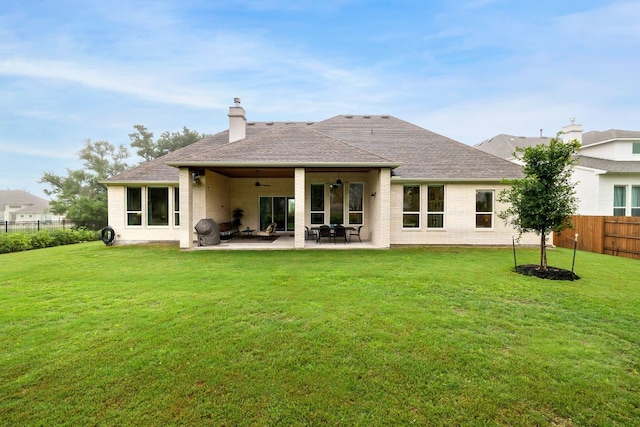 rear view of house featuring a yard, a patio area, a fenced backyard, and ceiling fan