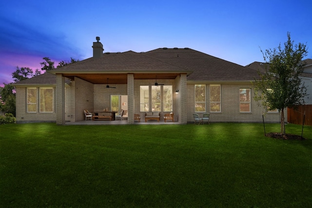 rear view of house featuring brick siding, a yard, a patio, a ceiling fan, and fence