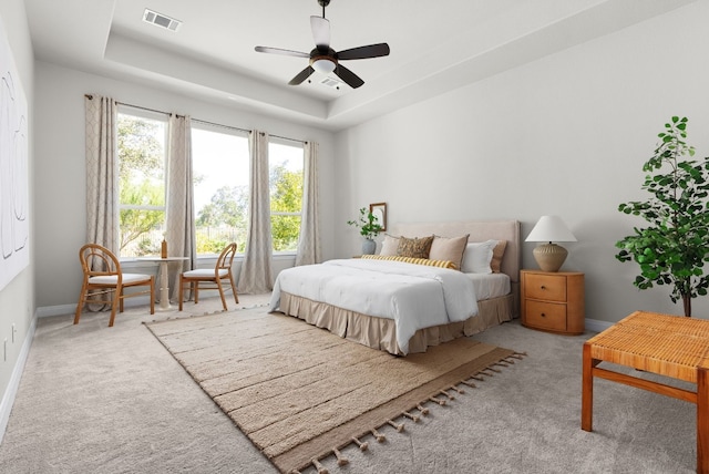 bedroom featuring a raised ceiling, visible vents, light carpet, and baseboards