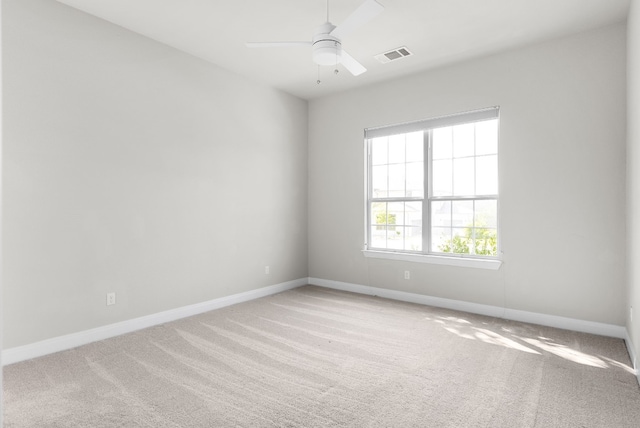 unfurnished room featuring a ceiling fan, light colored carpet, visible vents, and baseboards