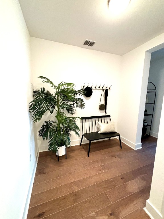 living area with baseboards, visible vents, and dark wood-type flooring