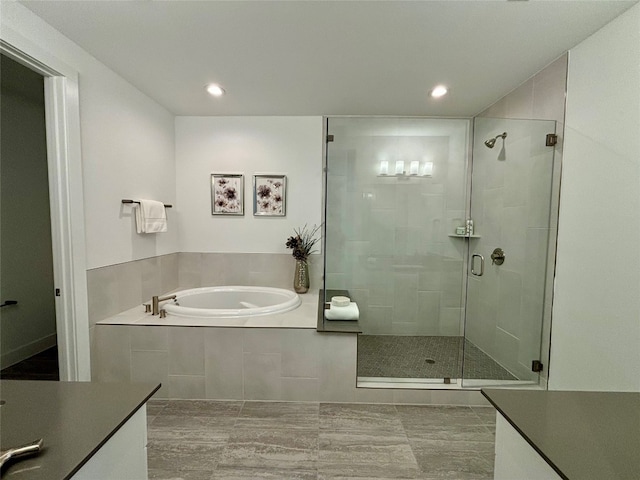 full bathroom with a stall shower, recessed lighting, a garden tub, and vanity