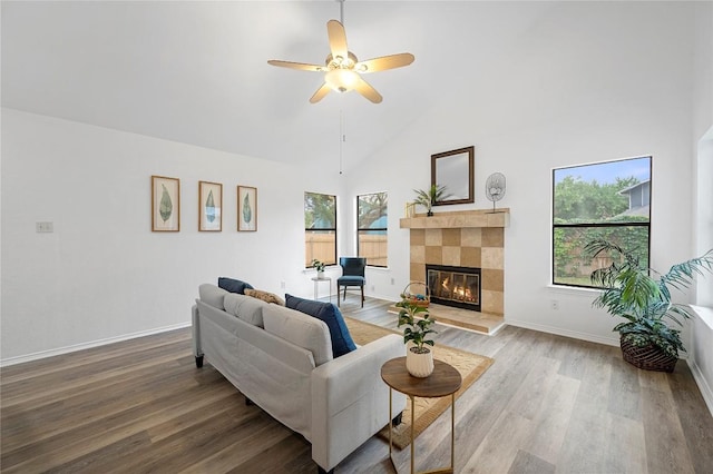 living room with ceiling fan, light wood-type flooring, a fireplace, and plenty of natural light