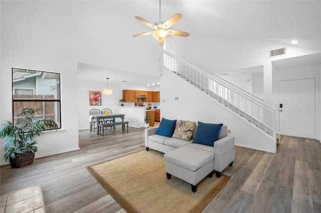 living room with high vaulted ceiling, light hardwood / wood-style flooring, and ceiling fan