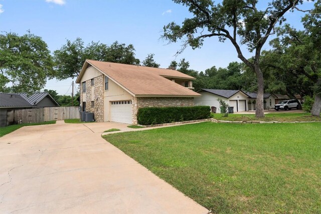 view of front of property with central AC and a front lawn