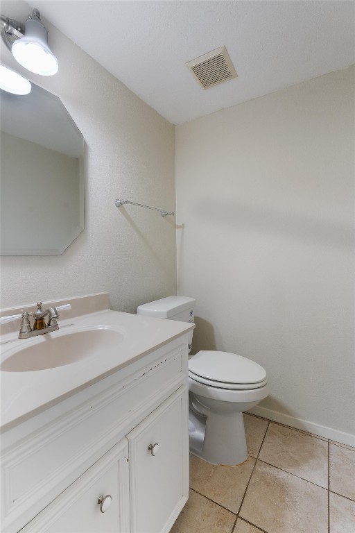 bathroom featuring tile patterned flooring, toilet, and vanity