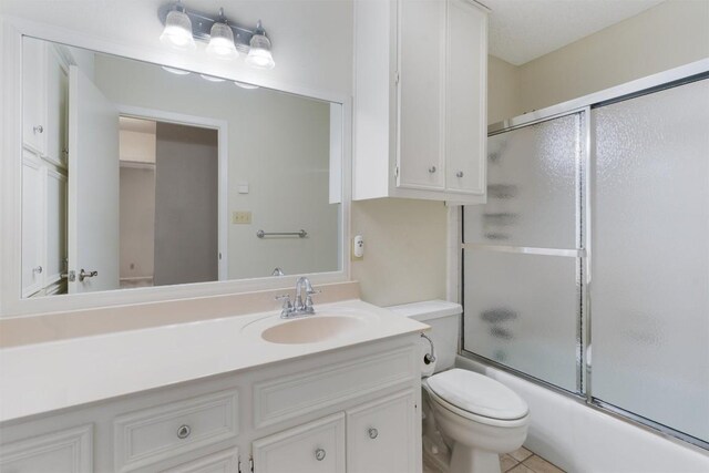 full bathroom featuring enclosed tub / shower combo, tile patterned flooring, vanity, and toilet