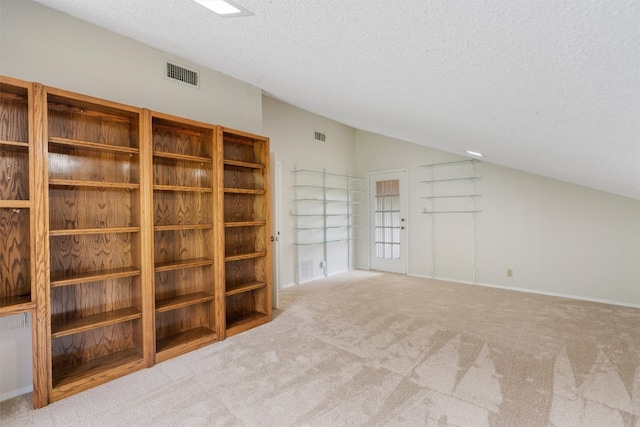 interior space with carpet, a textured ceiling, and lofted ceiling