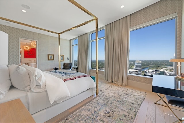 bedroom featuring wood-type flooring and a wall of windows