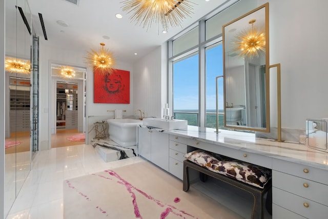 bathroom with a bathtub, tile patterned flooring, a water view, and a chandelier