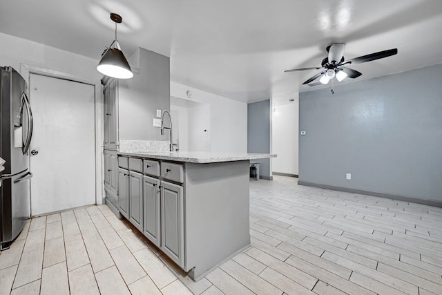 kitchen featuring stainless steel fridge with ice dispenser, gray cabinets, ceiling fan, and kitchen peninsula