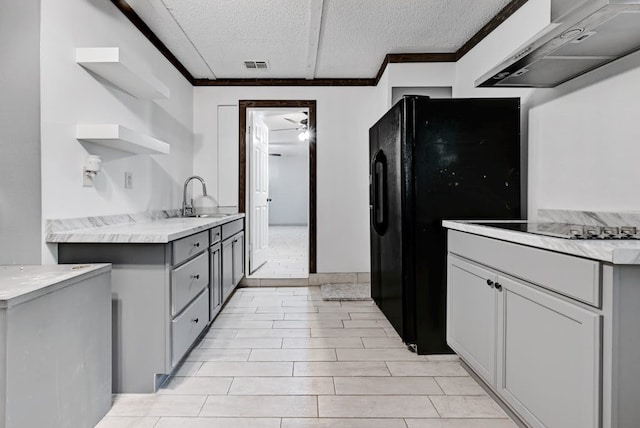 kitchen featuring ventilation hood, sink, a textured ceiling, gray cabinetry, and light tile floors