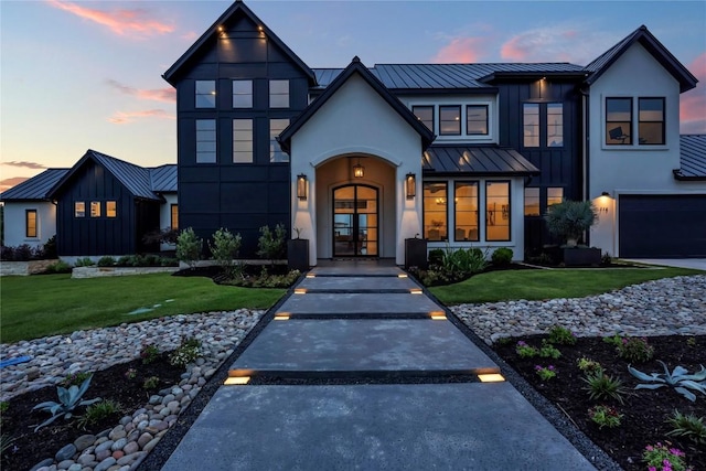 view of front of home with metal roof, a yard, french doors, board and batten siding, and a standing seam roof